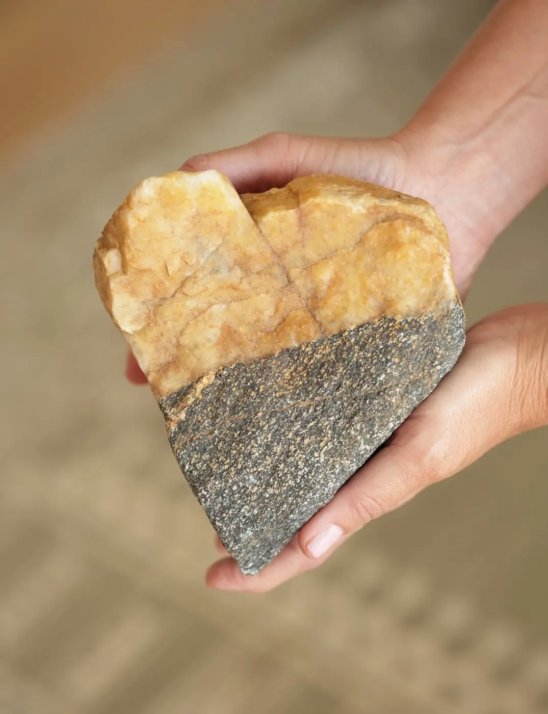 Hands holding a natural stone, a symbol of the Heart Stone Center